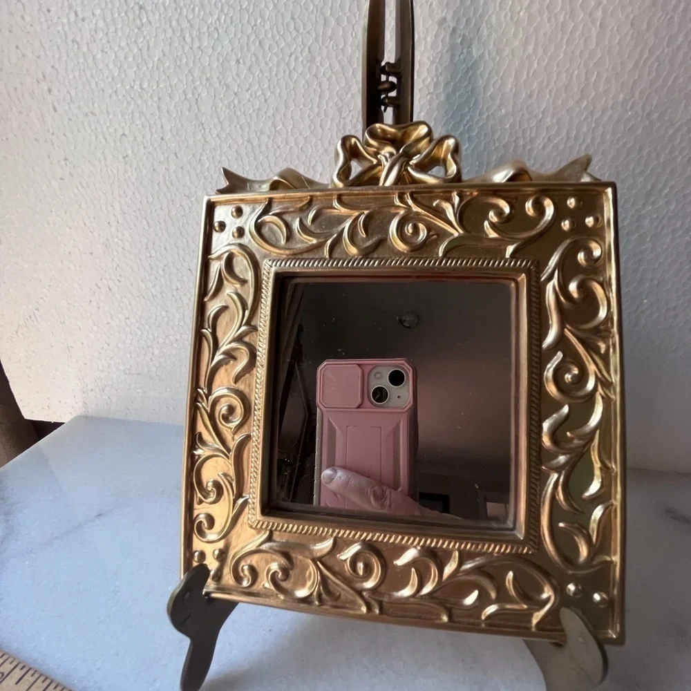 Vintage ornate gold wall mirror, accent mirror. Bow decorated frame